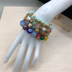 Curated bundle colorful stackable art glass and ceramic bracelets roll on.